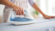 © Viks_jin - Close Up of Woman's Hands Ironing Clothes on Ironing Board at Home. Housewife Performing Domestic Chore, Laundry Care Routine with Modern Steam Iron Appliance. Housework Concept