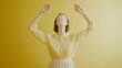 © Ilqara - A headless girl with arms raised in a conceptual photo, promoting novelty on a yellow background.