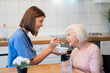 © zinkevych - Smiling woman nurse feeding soup to patient in hospital