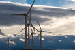 © yaqui_villegas - Close-up of wind turbines against dramatic clouds in Zaragoza, composition highlights silhouettes and visual rhythm in clean energy context