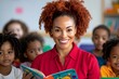 © Tanya - A smiling red-haired woman teacher in a pink blouse reads a children's book to an attentive group of preschoolers in a learning environment.