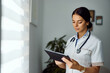 © bnenin - Medical Professional Working on Digital Tablet in Modern Healthcare Setting