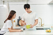 © Dialogue Frame - A young Asian couple in the kitchen, enjoying a simple breakfast with milk