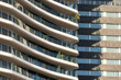 © yaqui_villegas - Curved facade detail of modern residential building with soft light, ideal for real estate, architecture and luxury apartment commercial imagery with copy space