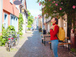 © Seleznov_Molchanova - Tourist woman enjoys historic charm of Hochst near Frankfurt, wandering through picturesque streets with old houses and cobblestone alleys, soaking in peaceful atmosphere of old town.