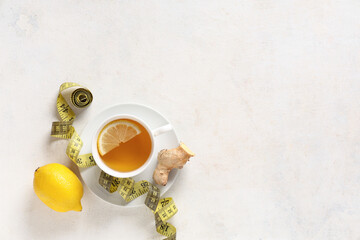 Wall Mural - Cup of diet tea, lemon, ginger root and measuring tape on light background. Weight loss concept