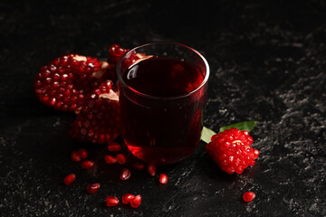 Wall Mural - glass of fresh pomegranate juice and seeds on black background