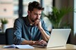 © yuntunen - Thoughtful man working on laptop in modern office setting