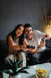 © Dusan - Young caucasian couple smile and play video games on joystick