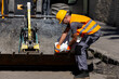 © zphoto83 - Construction worker handling materials on a busy urban street during daylight hours