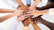 © Windy Junes - Diverse hands of different skin tones and sizes stacked in circle formation against white background showing unity and teamwork in collaborative gesture