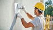 © Irybka - A Hispanic construction worker applying paint to a wall at a worksite. Featuring care and detail