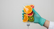 © TanTin - IV vitamin drip saline bag with fresh fruits slices held by gloved nurse hand on light backdrop, symbol of rejuvenation, revitalization, wellness, healthy living, benefits of vitamins. Copy space