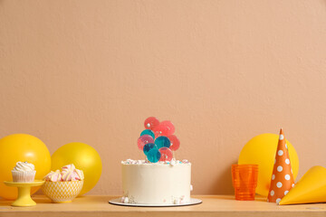Wall Mural - table with cake, sweets and balloons for birthday party against beige wall