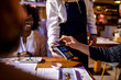 © Marko Geber - Young man paying with his credit card in a sushi restaurant