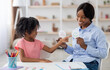 © Prostock-studio - Female teacher friendly pretty young black woman and little girl preschooler exercising at daycare, learning about emotions, copy space. Child development, emotional intelligence for kids concept