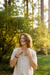 © Leah Flores/Stocksy - Smiling Teen Standing in Sunshine at Forest Park