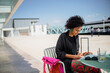 © tessy morelli/Stocksy - Lisbon woman at cafe by the river