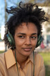 © tessy morelli/Stocksy - Close portrait of woman listening music in the park
