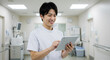 © 9bdesign - Japanese nurse using tablet, AI generated