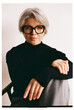 © Viktor Solomin/Stocksy - Mature woman with gray hair poses confidently in a chic outfit