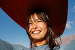 © Adrian Rodd/Stocksy - Close-up portrait of surfer balancing a surfboard on her head