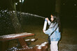 © Inna Reznik/Stocksy - Girl spraying artificial snow into the air at night