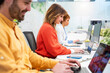 © Santi Nuñez/Stocksy - Office workers typing on laptops, working together in modern office