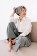 © Viktor Solomin/Stocksy - Mature woman poses elegantly on a sofa while enjoying a life moment