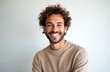 © miss irine - Handsome man with curly hair smiles. Guy with friendly expression, shows white teeth. Happy young adult with beard, casual wear. Great for commercial, lifestyle projects, advertisement.