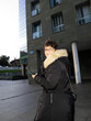 © Alvaro Lavin/Stocksy - Smiling businesswoman using smartphone while walking