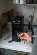 © Laura Stolfi/Stocksy - Man's hand and freshly made espresso
