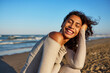 © Javier Díez/Stocksy - Bright sunny day at the beach with a smiling young woman