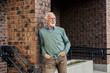 © Dusan Petkovic - Portrait of casual trendy senior man leaning on the wall on city street and enjoying music.