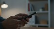 © Firman Dasmir - Engaged hands using a smartphone in a modern, softly lit domestic workspace