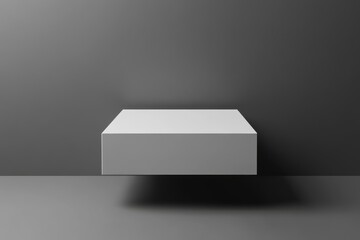 Fototapete - Minimalist display of a floating white box against a dark gray wall and surface in a contemporary setting