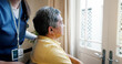 © peopleimages.com - Memory, nurse and senior man by window for thinking, reflection or remember for dementia. Planning, ideas and elderly male patient in wheelchair with caregiver by glass door in assisted living.