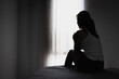 © Tinnakorn - Silhouette of Young women sitting in dark room feeling pain with life problem. suffering from husband violence, Stop violence against and sexual abuse women, domestic violence, anti human trafficking.
