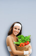 © vgstudio - Portrait image of happy smile woman in fitness wear hold grocery shop bag with raw food, vegetables, isolate grey gray background. Healthy diet eating, sale ad concept. Vertical banner with free space