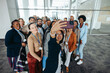 © Jacob Lund - Corporate team of diverse colleagues taking a group selfie at the office