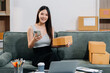 © NINENII - small business entrepreneur SME or freelance asian woman working with box at home.