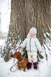 © Yanina - little girl holding a dog on a leash in snow