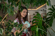© Migma_Agency - Woman cleaning houseplants leaves with spray bottle and microfiber cloth