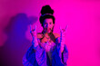 © deagreez - Elegant young woman dressed in a vintage royal style costume making funny expressions under vibrant pink neon lighting