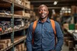 © Baba Images - Portrait of happy African American salesman standing in appliance showroom