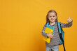 © New Africa - Cute schoolgirl with backpack and books showing thumbs up on yellow background. Space for text