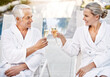 © Penn/peopleimages.com - Happy, senior couple and champagne with glasses at spa for outdoor anniversary, date or cheers at luxury resort. Man and woman touching with drink for toast, celebration or holiday getaway at hotel