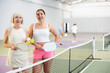 © JackF - Women with racquets and balls standing in pickleball court and looking at camera