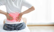 © Ton Photographer4289 - Woman holding her lower back while sitting in bed has chronic back pain. Health Care concept.