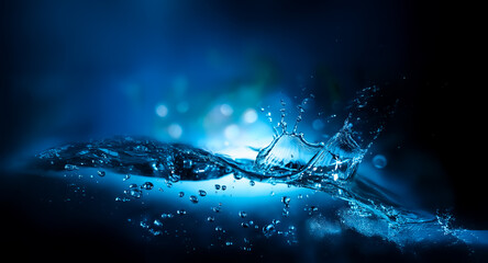 Leinwandbilder - Blue water splash with bubbles in motion against a dark, blurry background with bokeh lights. Dynamic and refreshing water scene.